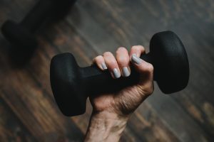 Black dumbbell being held by a wowan's hand